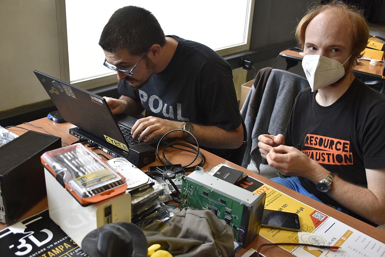Technology specialists working at a laptop on security work.