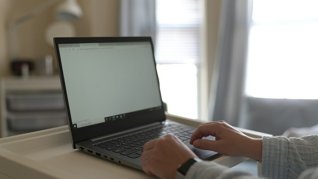 A person working on a laptop at a home desk, illustrating the accounts to secure after a data breach