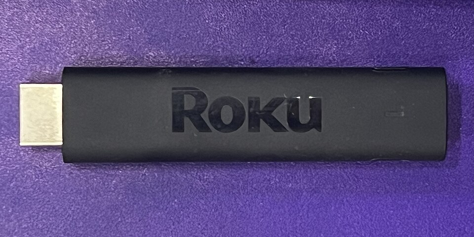 Roku streaming stick plugged into a television.